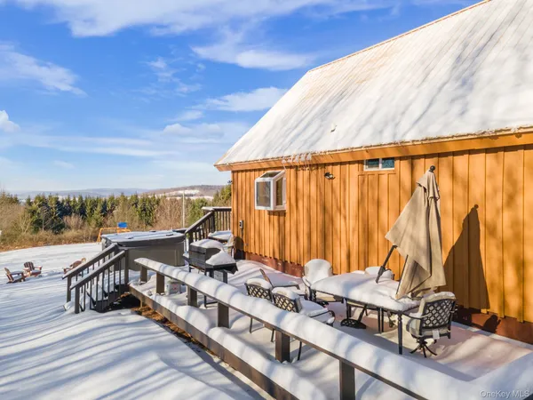 a view of a balcony with chairs and wooden floor