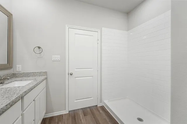 a bathroom with a granite countertop sink a mirror and a bathtub