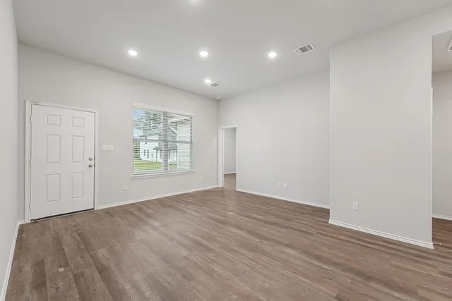 wooden floor in an empty room with a window