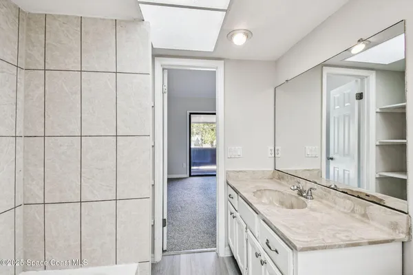 a bathroom with a granite countertop sink and a mirror