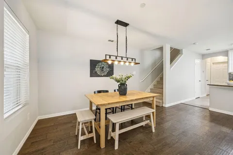 a room with table chairs and wooden floor