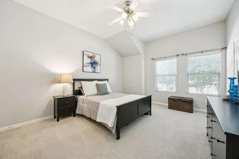 a spacious bedroom with a bed and a chandelier