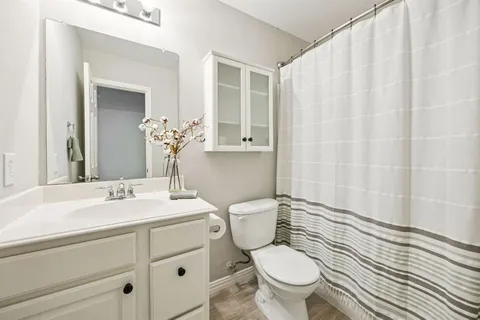 a bathroom with a granite countertop sink a toilet and a mirror