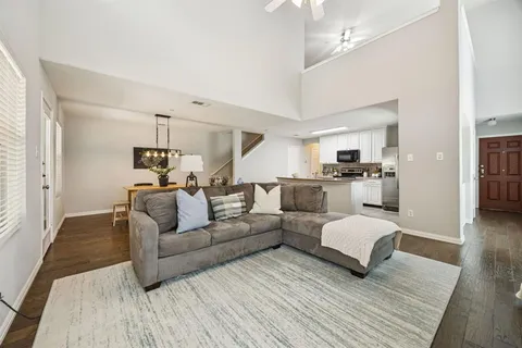 a living room with furniture and a wooden floor