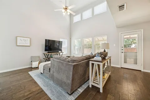 a living room with furniture a flat screen tv and wooden floor