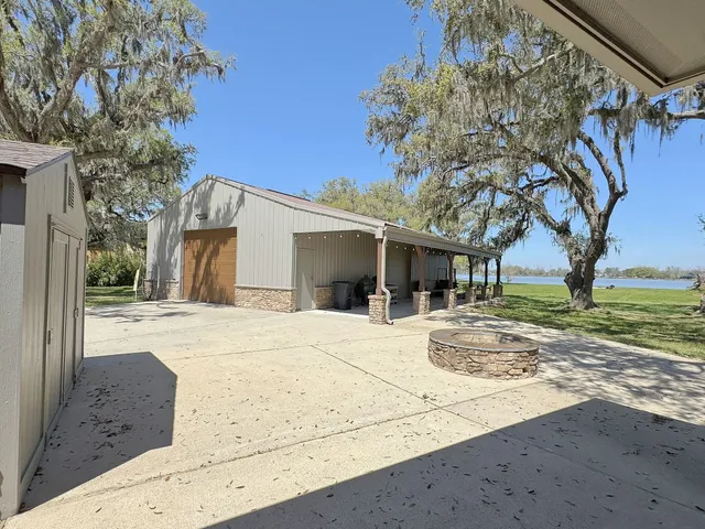 a view of a house with a yard and large tree