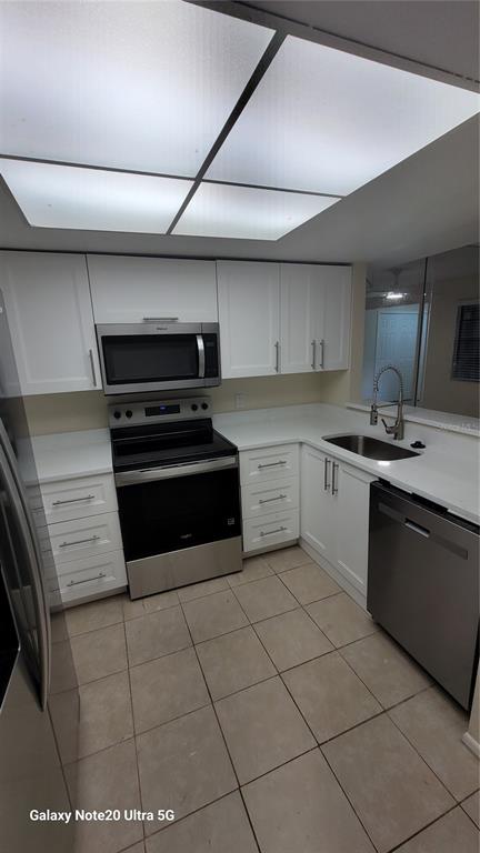 12025 Proctor Loop, Unit 1 New Port Richey, FL 34654 - Photo 4 of 11 a kitchen with stainless steel appliances granite countertop a sink and cabinets