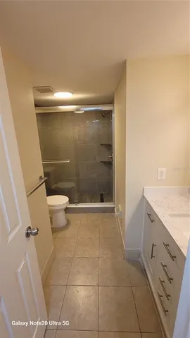 a bathroom with a granite countertop toilet and a sink