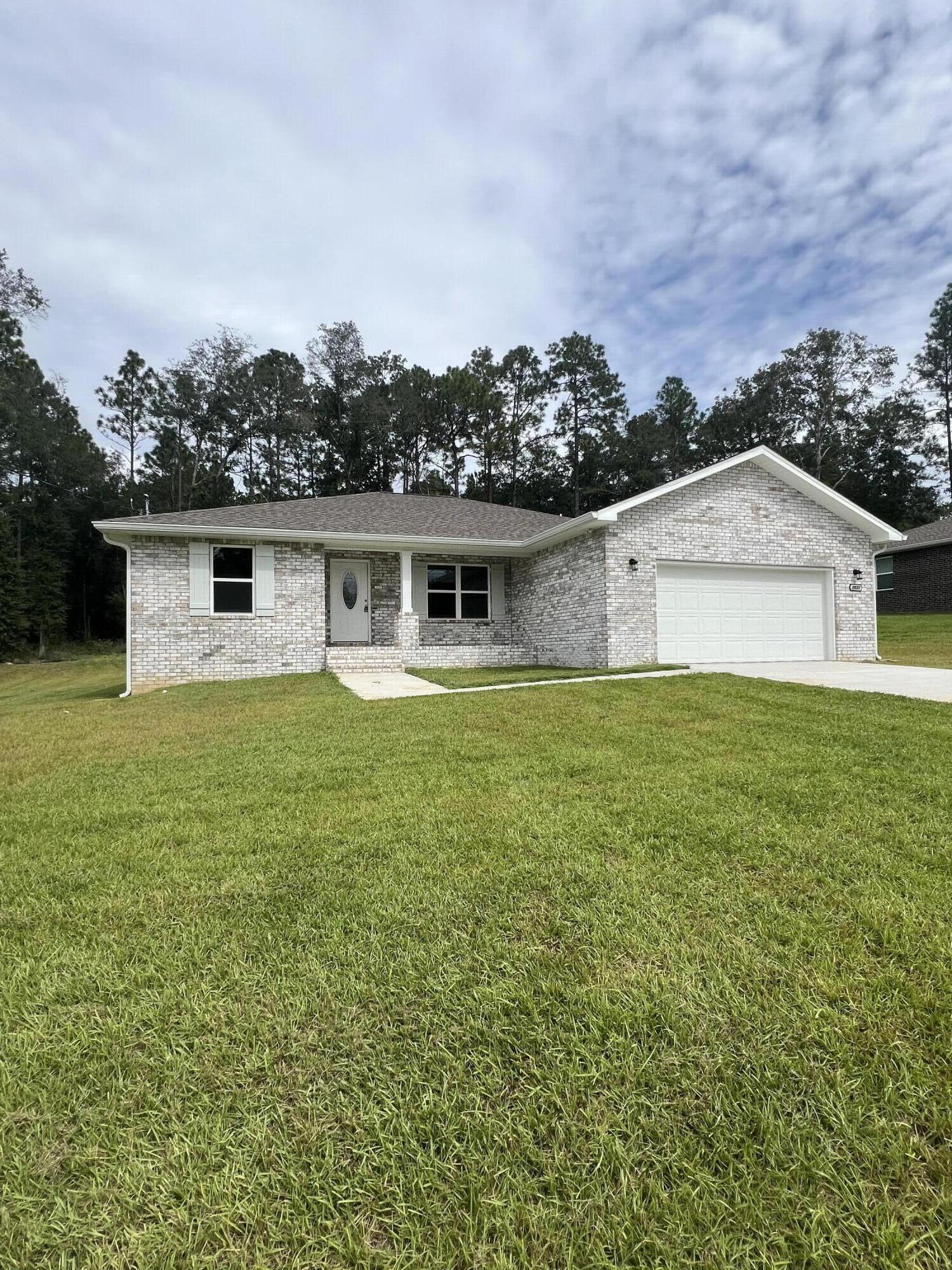 3931 Poverty Creek Road Crestview, FL 32539 - Photo 1 of 34 a front view of a house with a garden and yard