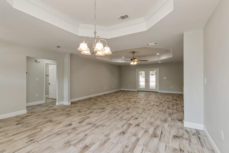 3931 Poverty Creek Road Crestview, FL 32539 - Photo 17 of 34 an empty room with wooden floor and windows
