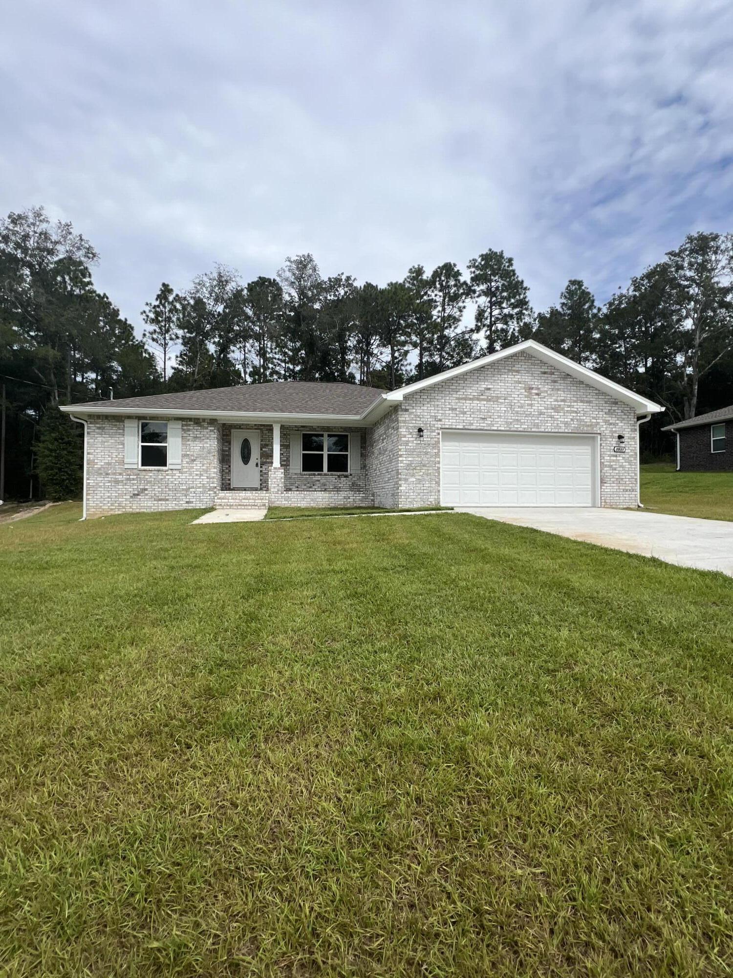 3931 Poverty Creek Road Crestview, FL 32539 - Photo 2 of 34 a view of a house with a yard and a large tree