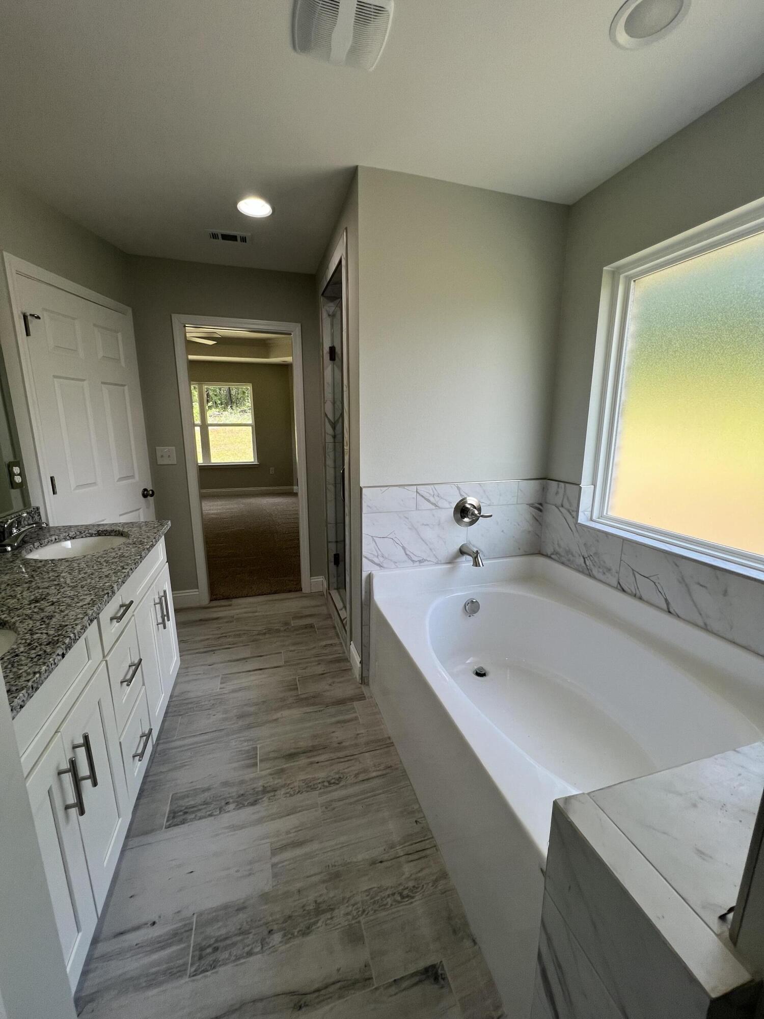 3931 Poverty Creek Road Crestview, FL 32539 - Photo 33 of 34 a large bathroom with a tub sink and mirror