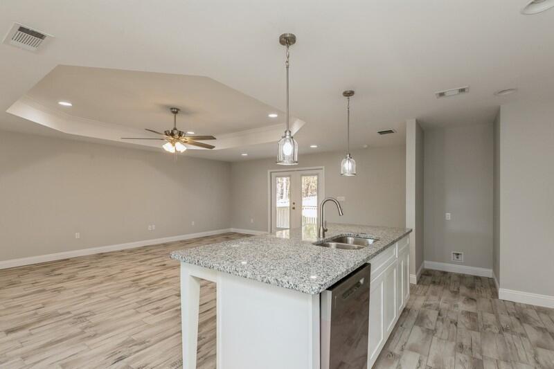 3931 Poverty Creek Road Crestview, FL 32539 - Photo 7 of 34 a hall with kitchen island granite countertop a sink a counter space and a view of kitchen