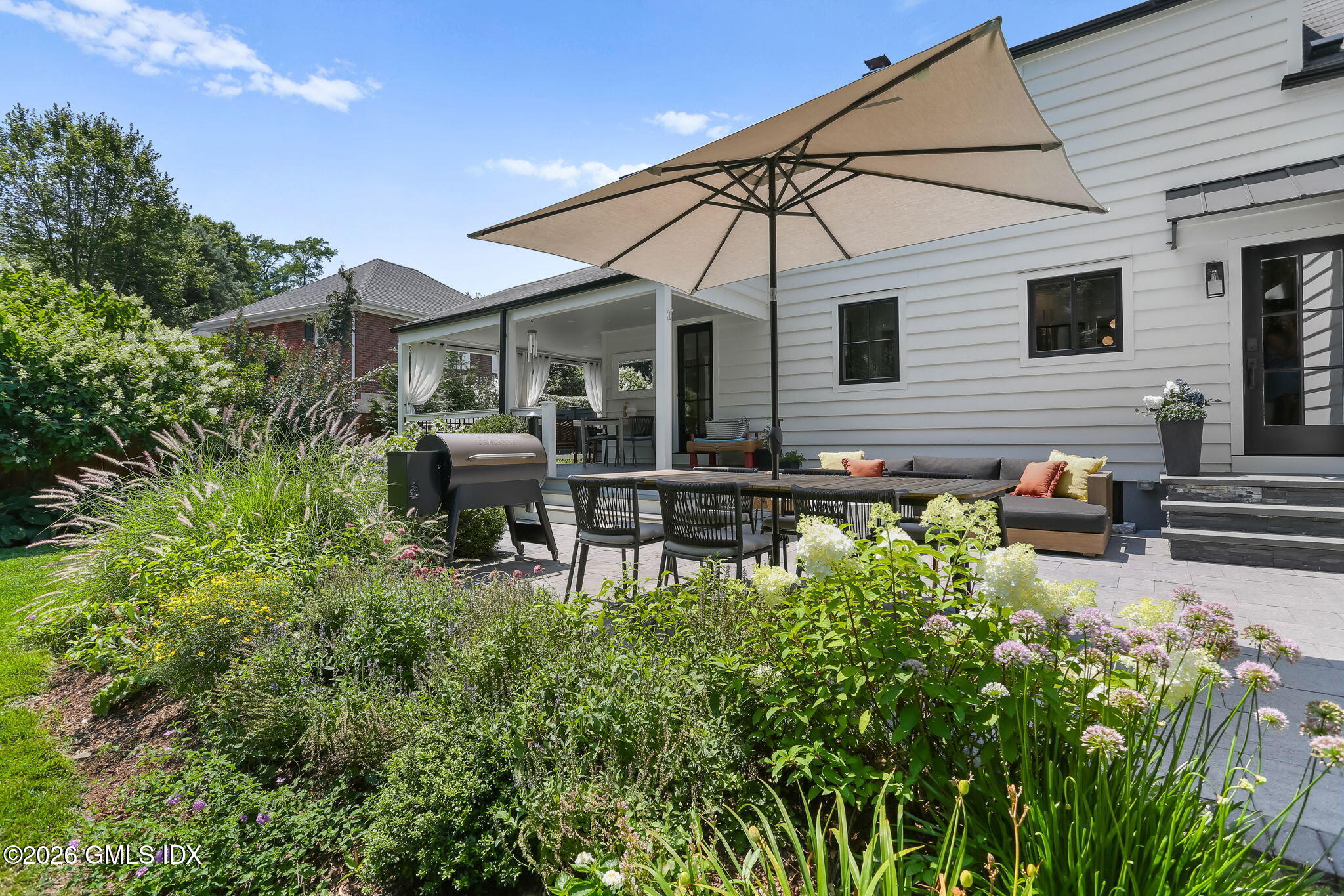 39 Indian Field Road Greenwich, CT 06830 - Photo 4 of 8 a view of a chair and table in the backyard of the house