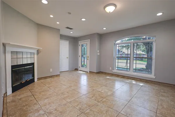 a view of an empty room with a fireplace and a window