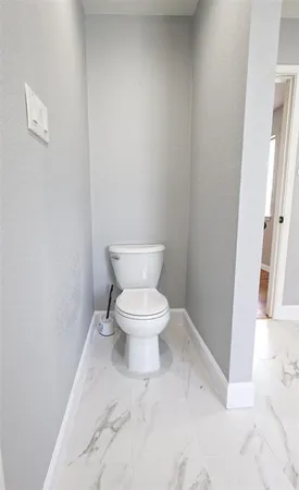 a white toilet sitting next to a white walls