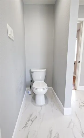 a white toilet sitting next to a white walls
