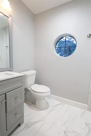 a bathroom with a toilet a sink and mirror