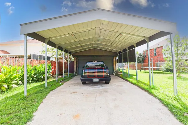 a car parked in front of a house with wooden fence
