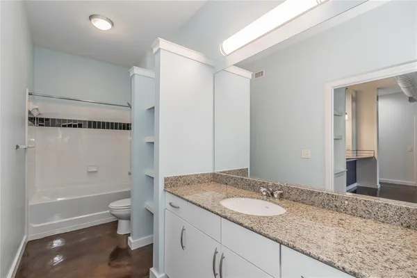 a view of an empty room with window and chandelier fan