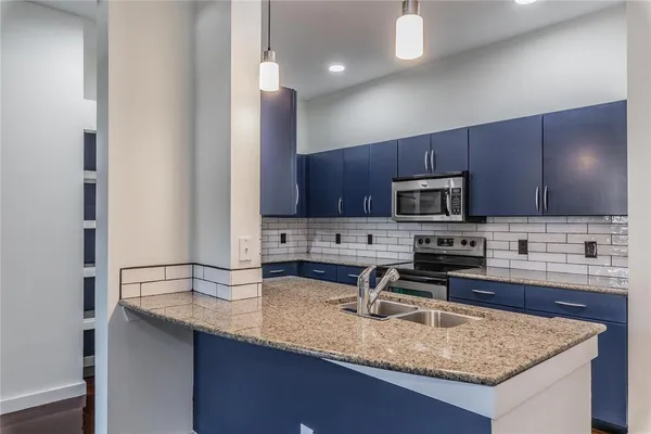 a kitchen with stainless steel appliances granite countertop a sink stove and refrigerator