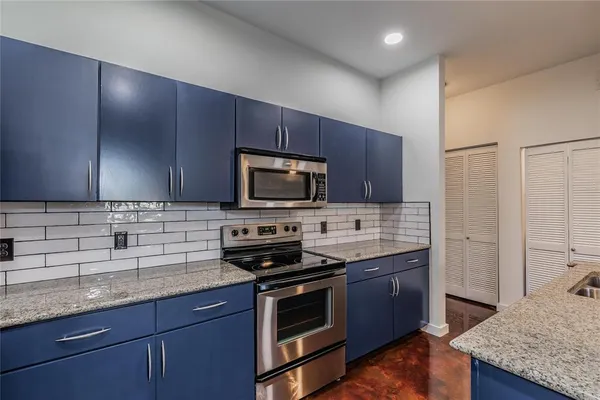 a kitchen with stainless steel appliances granite countertop a stove a sink and a microwave