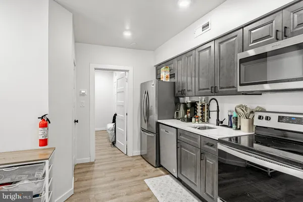 a kitchen with stainless steel appliances granite countertop a refrigerator and a stove top oven