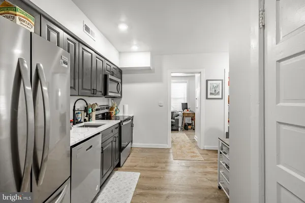 a kitchen with stainless steel appliances granite countertop a refrigerator and a sink