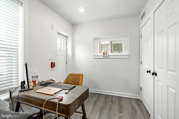 a view of a workspace with furniture and a window