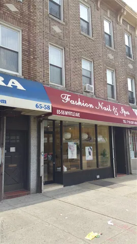 a view of a building with a couple of cars parked in front of house