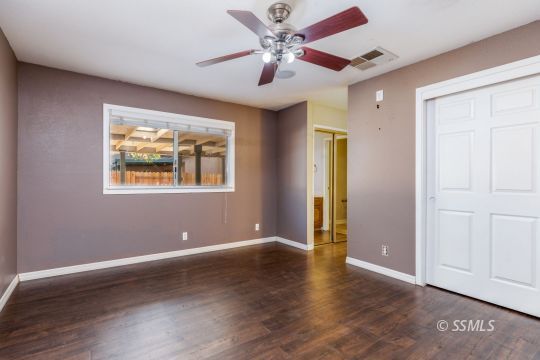 613 South Silver Ridge Street Ridgecrest, CA 93555 - Photo 22 of 26 a view of an empty room with window and wooden floor