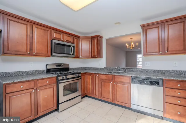 a kitchen with granite countertop cabinets stainless steel appliances and a counter space