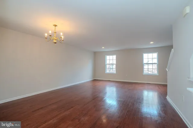 an empty room with wooden floor and window