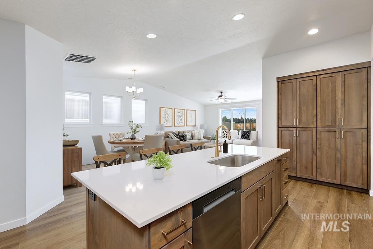 1700 East Hadler Street Meridian, ID 83642 - Photo 25 of 25 Kitchen with open floor plan, stainless steel dishwasher, a kitchen island with sink, light wood-style floors, and lofted ceiling