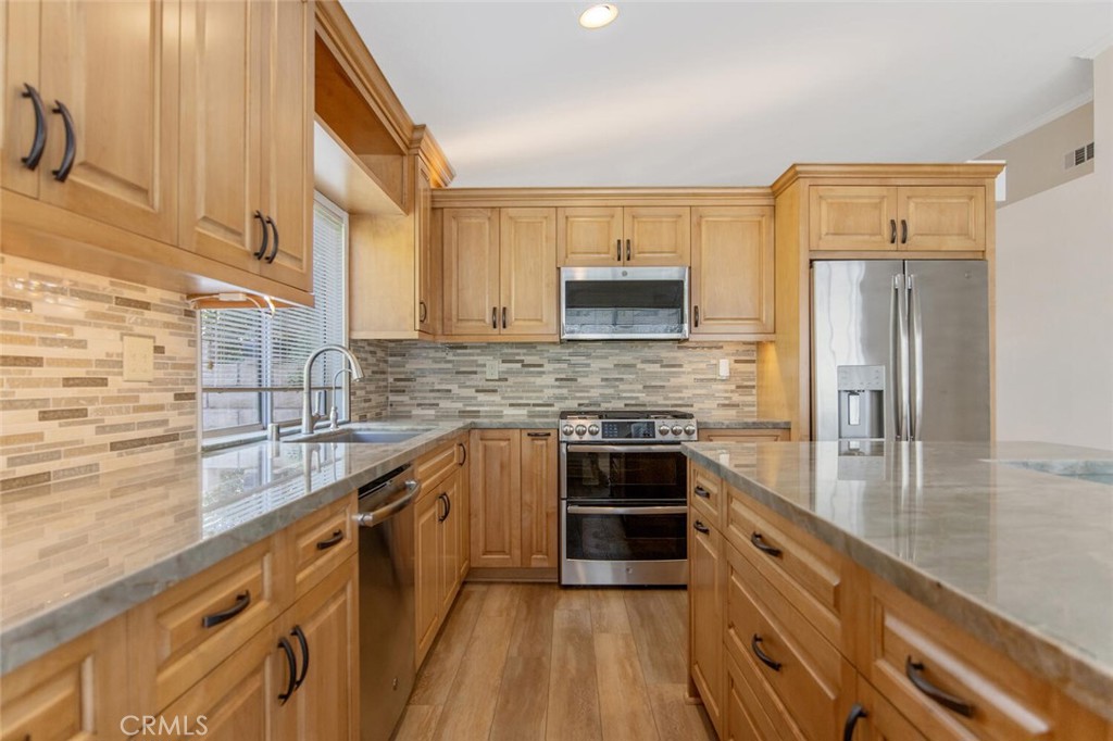 27619-27619 Ron Ridge Drive Saugus, CA 91350 - Photo 12 of 37 a kitchen with kitchen island granite countertop a sink stove and refrigerator