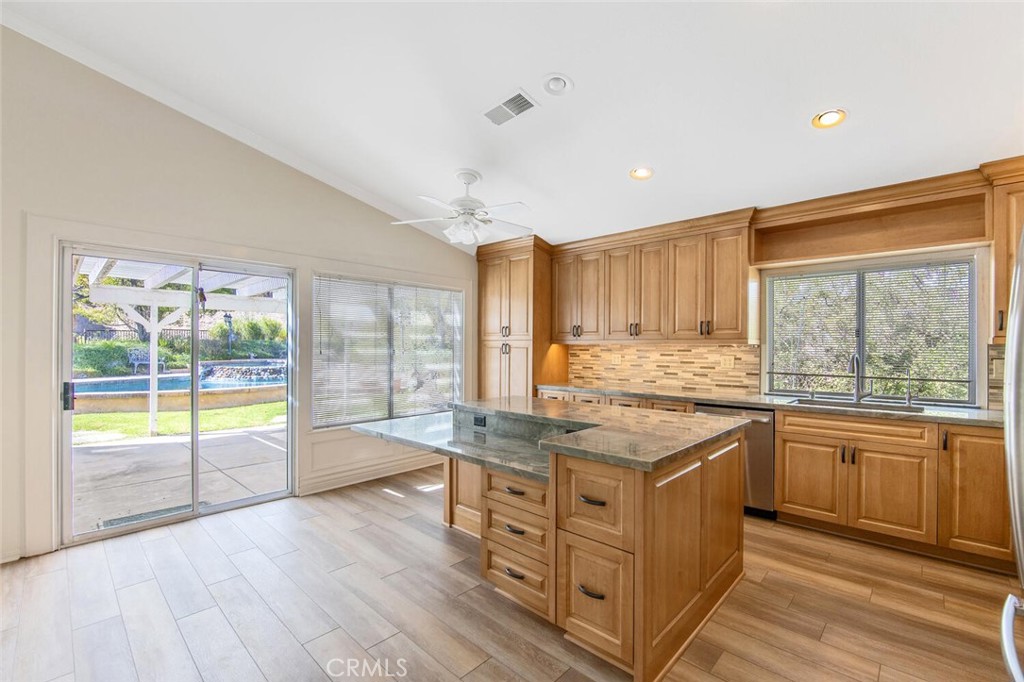 27619-27619 Ron Ridge Drive Saugus, CA 91350 - Photo 13 of 37 a kitchen with stainless steel appliances granite countertop a stove and a view of living room