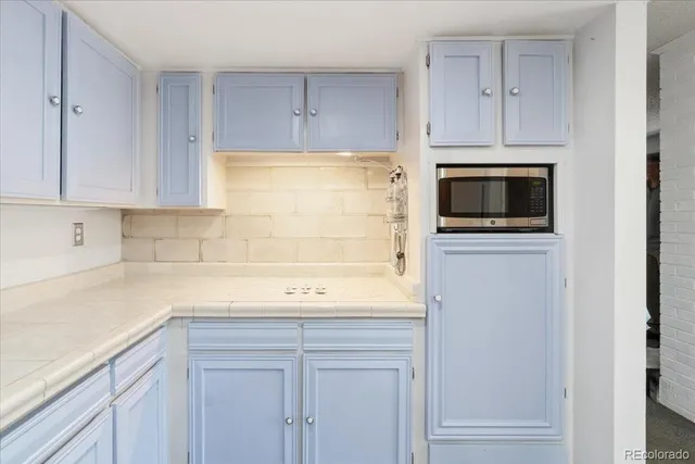 a kitchen with stainless steel appliances granite countertop white cabinets and a sink