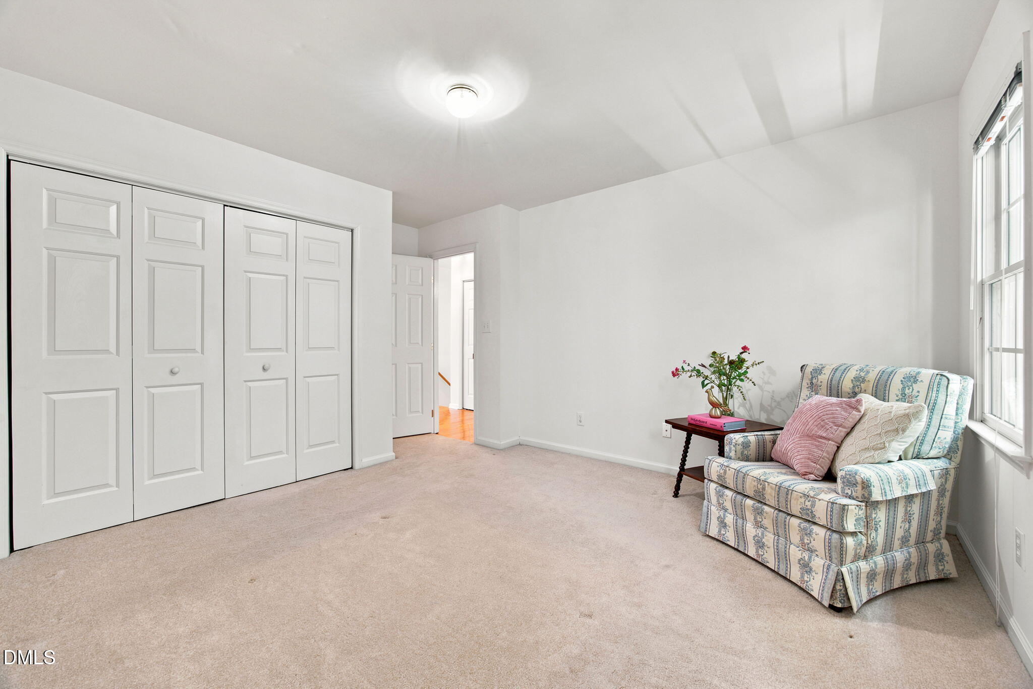 8211 Hempshire Place, Unit 104 Raleigh, NC 27613 - Photo 24 of 34 Carpeted room featuring bi-fold closet doors, a window, and a ceiling-mounted light fixture