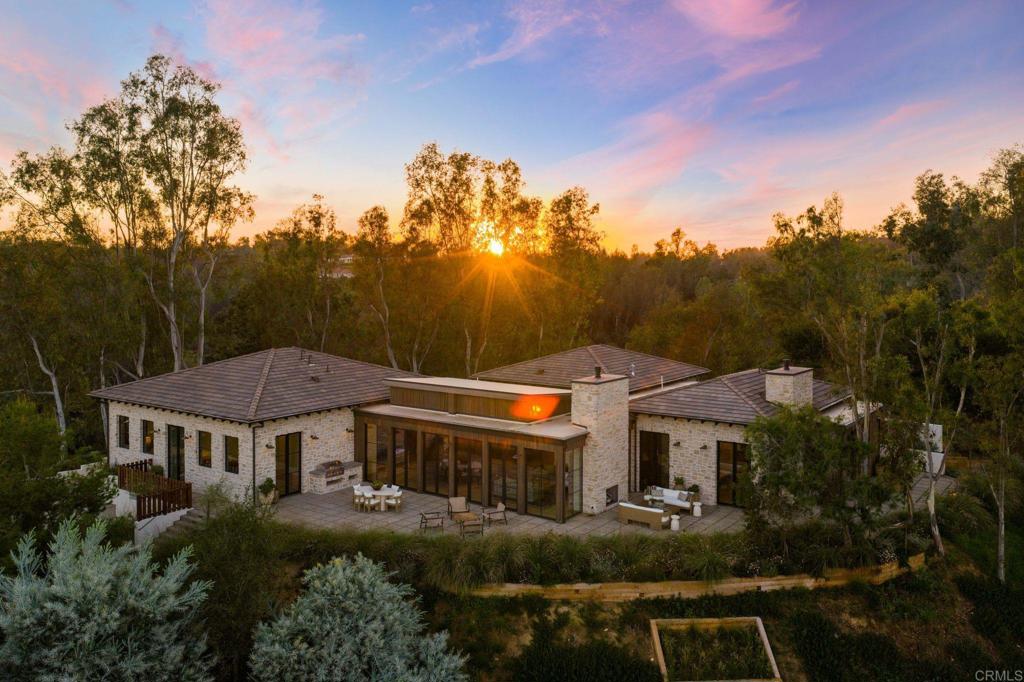 a view of a big house with a big yard plants and large trees