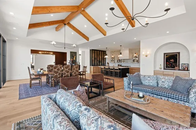 a living room with furniture a large window and a chandelier