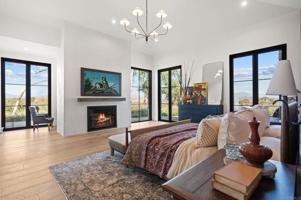 15816 Via Del Alba Rancho Santa Fe, CA 92067 - Photo 22 of 50 a bedroom with a bed couches and fireplace with wooden floor