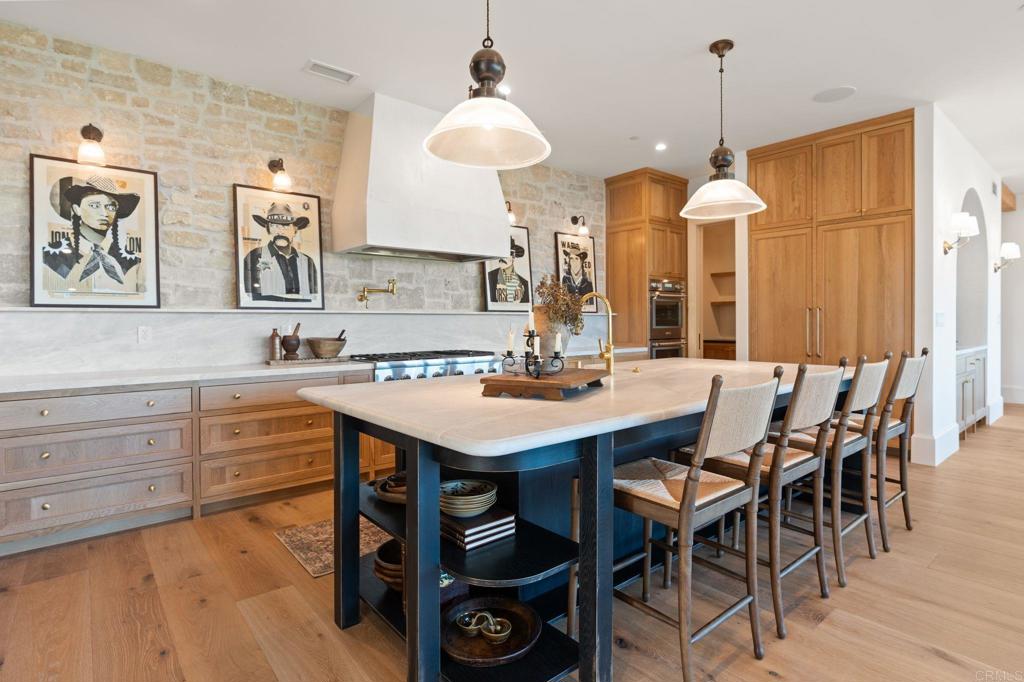 15816 Via Del Alba Rancho Santa Fe, CA 92067 - Photo 5 of 50 a kitchen with a table chairs sink and cabinets