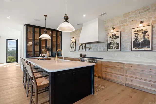 a large kitchen with stainless steel appliances a sink and cabinets