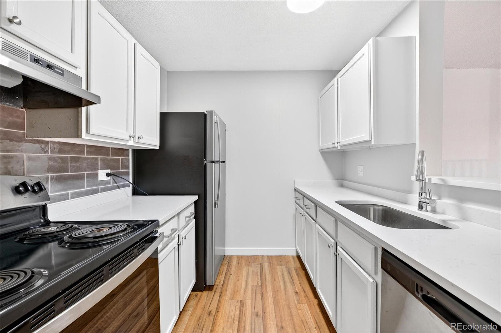 2281 South Vaughn Way Aurora, CO 80014 - Photo 12 of 23 a kitchen that has a sink and a stove
