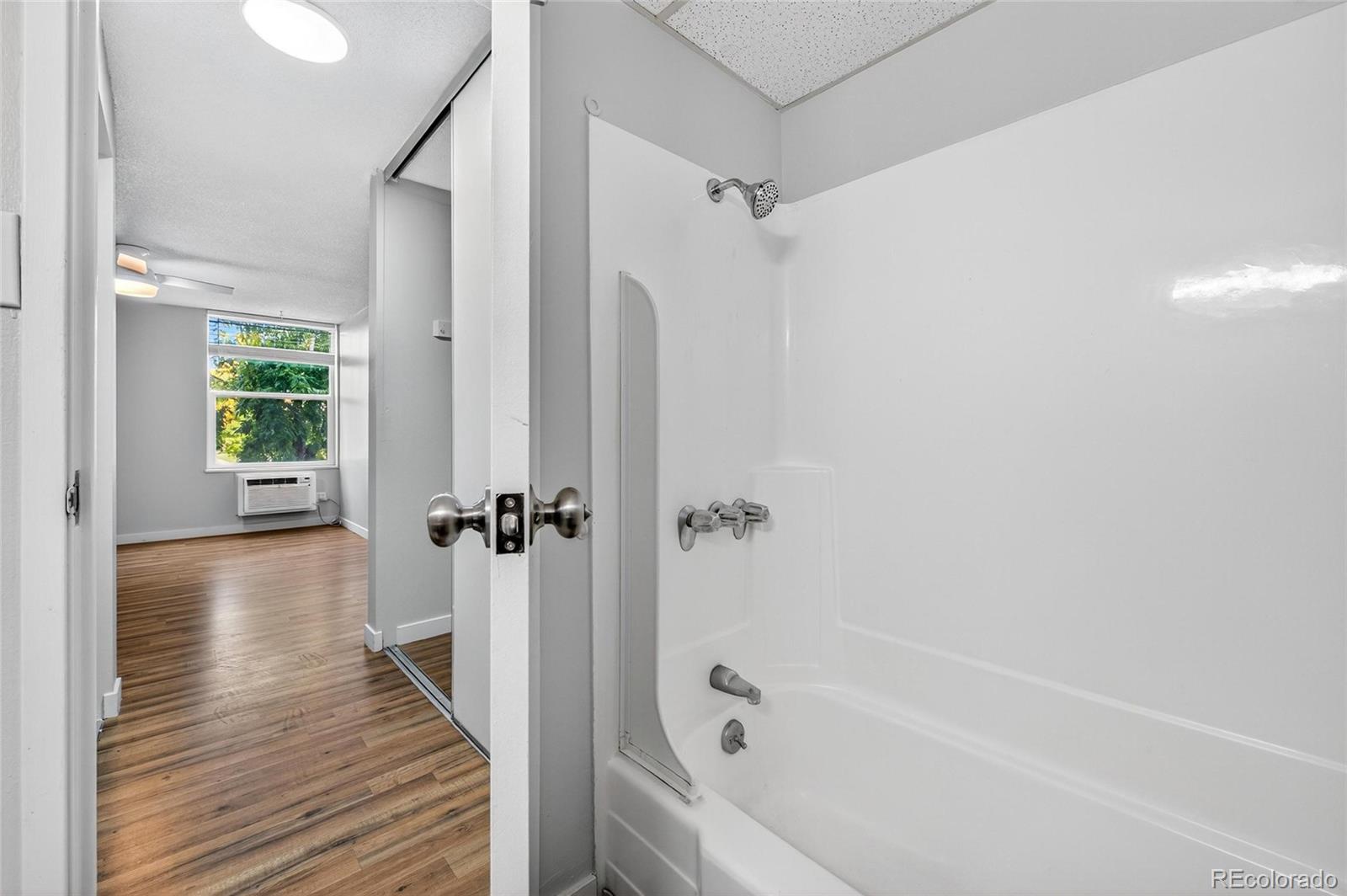 2281 South Vaughn Way Aurora, CO 80014 - Photo 16 of 23 a bathroom with a bathtub and a shower