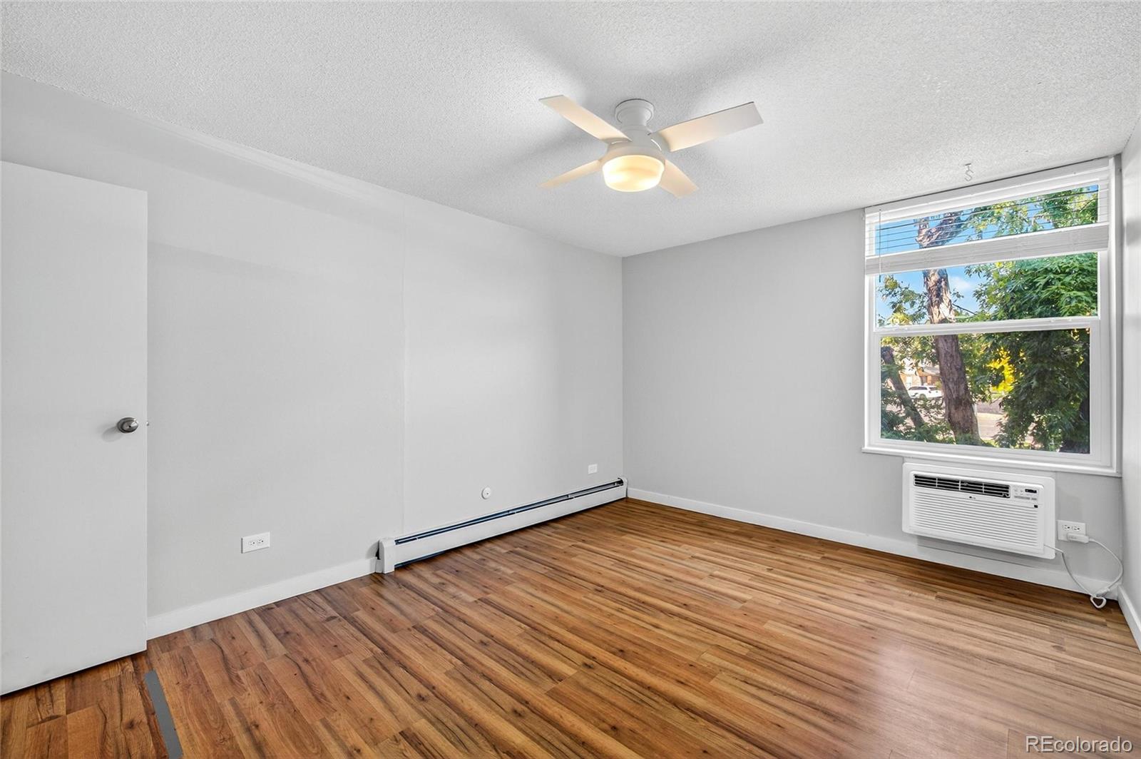 2281 South Vaughn Way Aurora, CO 80014 - Photo 20 of 23 wooden floor in an empty room with a window