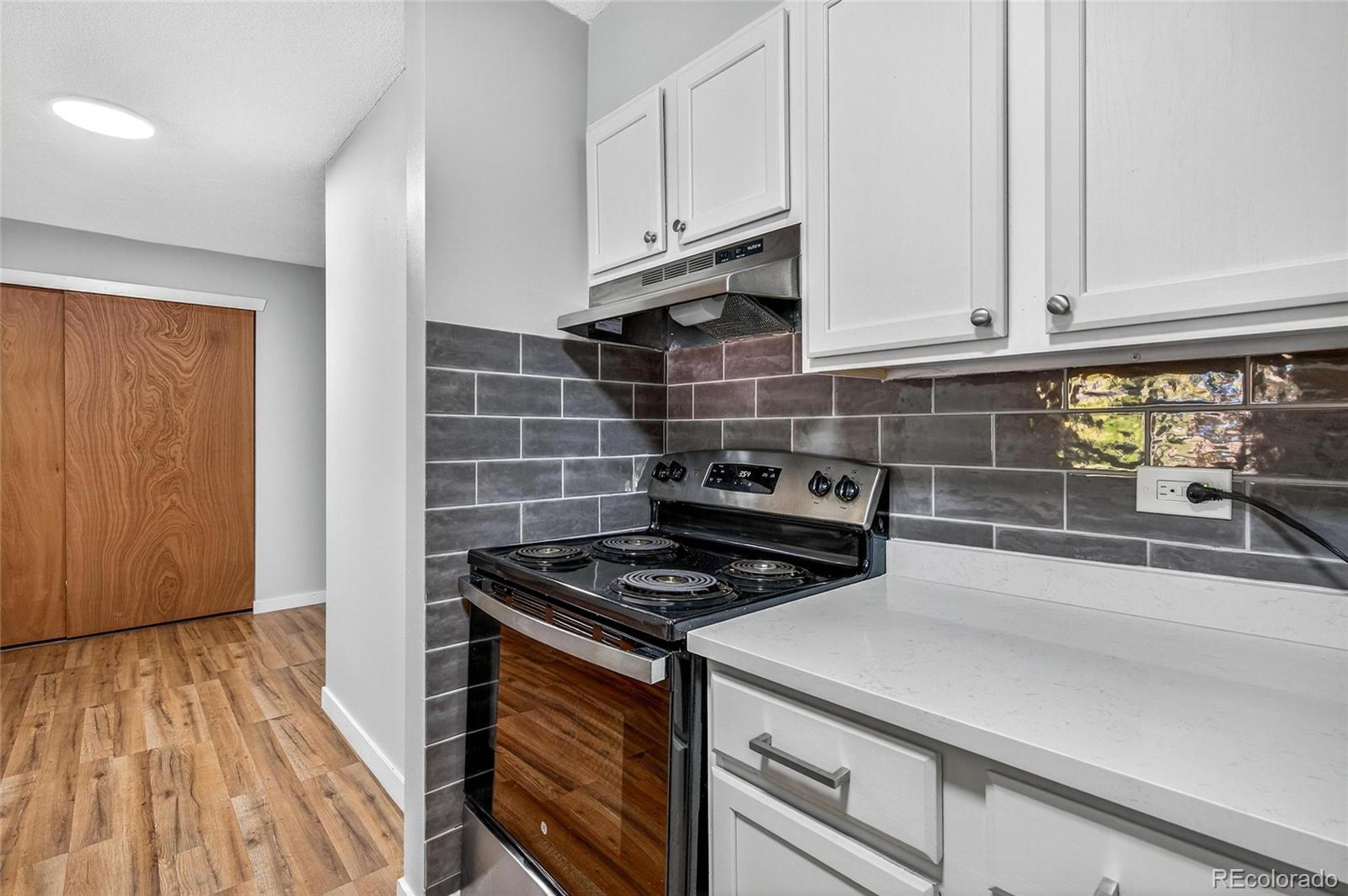 2281 South Vaughn Way Aurora, CO 80014 - Photo 9 of 23 a kitchen with granite countertop a stove and cabinets