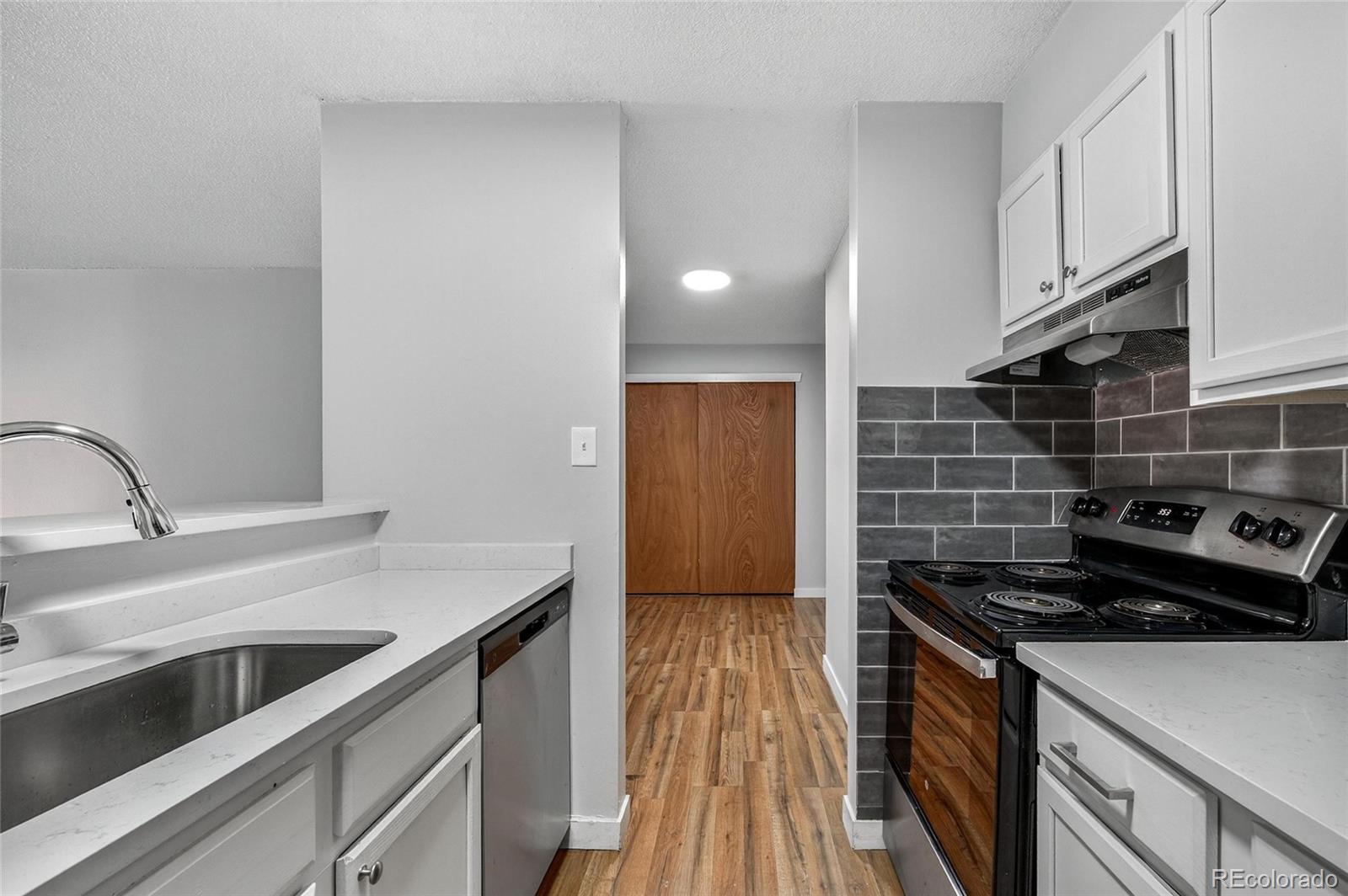2281 South Vaughn Way Aurora, CO 80014 - Photo 10 of 23 a kitchen that has a sink and a stove