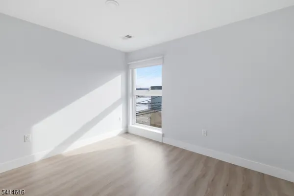 a view of a room with wooden floor and a window