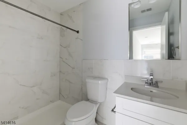 a bathroom with a sink toilet a mirror and shower